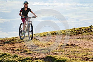 Girl child riding mountain bike at sunset