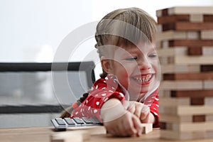 Girl child sit table and laughs while playing game