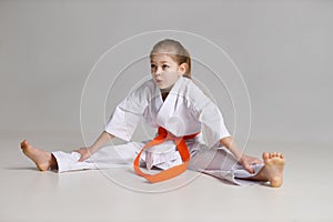 Girl child sits on a twine in a kimono on a white background