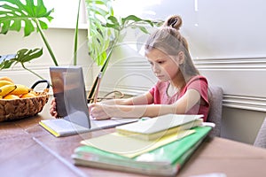 Girl child studying at home using digital tablet