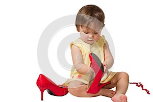 Girl-child trying on mother's big red shoes