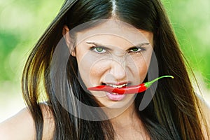 Girl with chili pepper in teeth