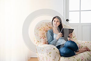 Girl chilling at home while using tablet.