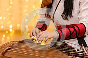 A girl in chinese traditional costumes played guzheng.