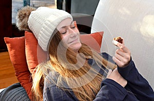 Girl with chocolate in hand on couch in winter