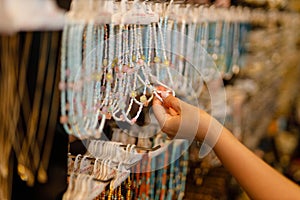 girl chooses beads on a display window in a store