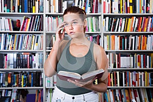 Girl chooses a book in the library