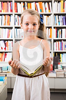 Girl chooses a book in the library