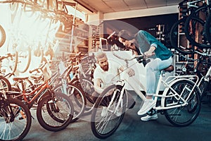 Girl Chooses City Bike with Seller in Sport Store