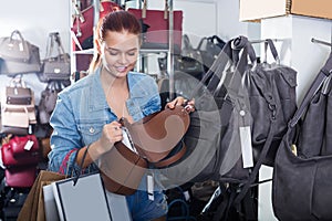 girl choosing handbag in store.