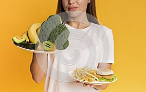 Girl choosing between organic fruits and vegetables and junk food