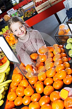 Girl choosing sweet citrus fruits