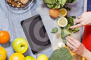 Girl chopping broccoli, copy space, tablet on counter