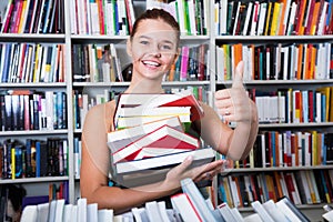 Girl chose a lot of books in university library