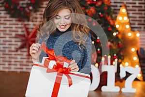 Girl with Christmas gift near beautiful dressed Christmas tree