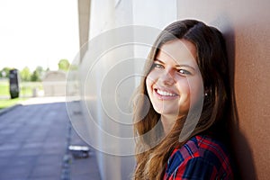 Girl city portrait. Woman smiling outside in evening light by th