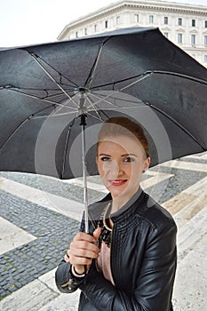 Girl in the city walking in the rain, smiling