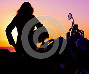 girl and classic motorcycle at sunset