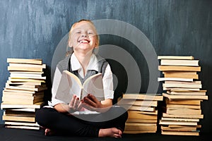 Girl, classroom and kid reading book for education, language learning and knowledge on chalkboard background. Child or