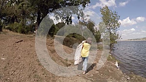 Girl cleaning a park from trash, slow motion