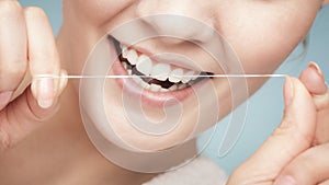 Girl cleaning teeth with dental floss. Health care