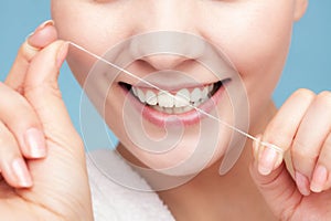 Girl cleaning teeth with dental floss. Health care