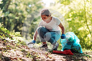 Girl cleaning up the forest and collecting trash