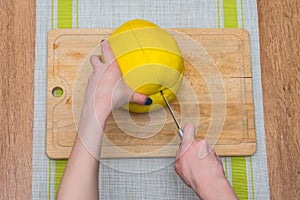 Girl cleans a pomelo on a wooden board