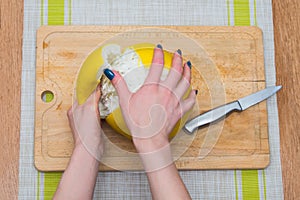 Girl cleans a pomelo on a wooden board