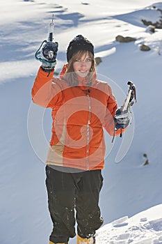 Girl climber climbs a snow cornice using ice axes through snow blown away by the strong wind. photo