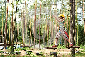 Girl at climbing activity in high wire forest park