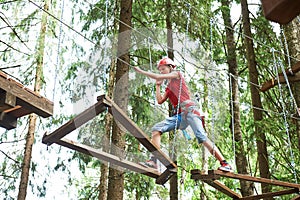 Girl at climbing activity in high wire forest park