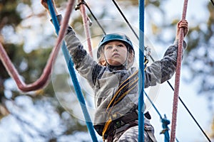 Girl climbing in adventure park , rope park