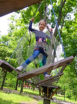 Girl climbing in adventure rope park