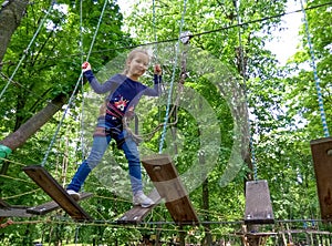 Girl climbing in adventure rope park