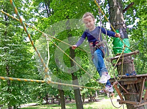 Girl climbing in adventure rope park