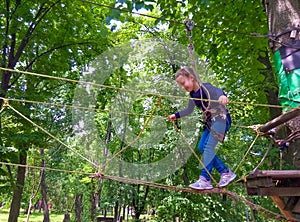 Girl climbing in adventure rope park