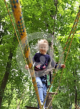 Girl climbing in adventure rope park