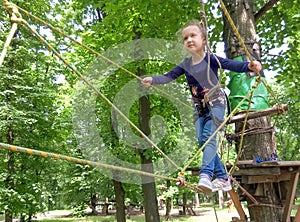 Girl climbing in adventure rope park