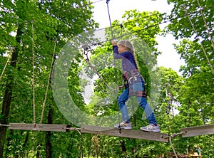 Girl climbing in adventure rope park