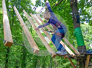 Girl climbing in adventure rope park