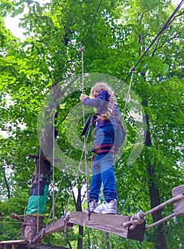 Girl climbing in adventure rope park