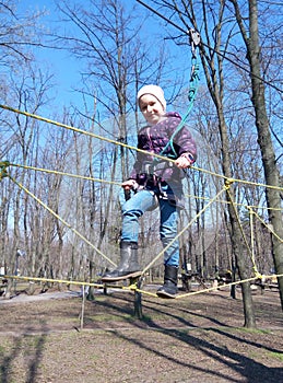 Girl climbing in adventure rope park