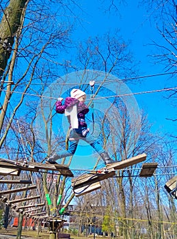 Girl climbing in adventure rope park