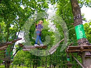 Girl climbing in adventure rope park