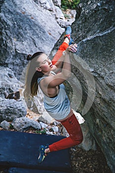 Girl climbing boulder.