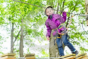 Girl climbing in high rope course