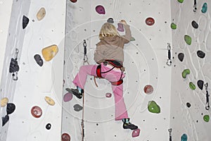 Girl is climbing on indoor wall