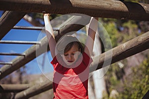 Girl climbing monkey bars during obstacle course training