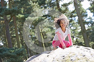 Girl Climbing On Rock In Countryside